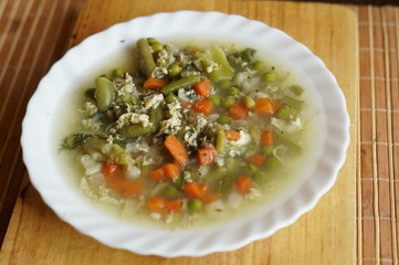 Boiled vegetables in a white plate on a chopping board