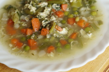 Boiled vegetables in a white plate on a chopping board