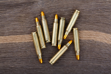 Rifle bullets on old wood desk.