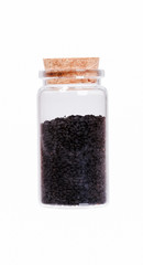 Nigella or Black cumin in a glass bottle with cork stopper, isol