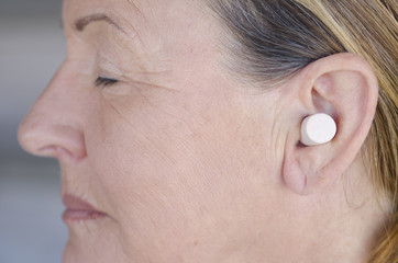 Woman blocking sound with ear plug closed eyes