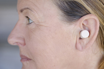 Woman blocking sound with ear plug