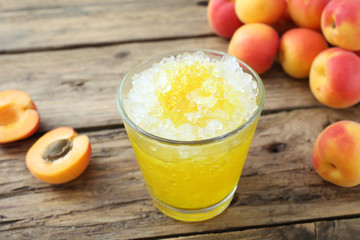 granita con sciroppo di albicocche in bicchiere sfondo rustico