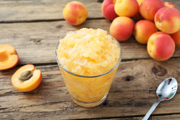 granita con frullato di albicocche in bicchiere sfondo rustico
