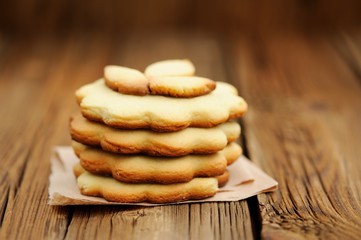 Four round sand cakes in pile decorated with three small leave c
