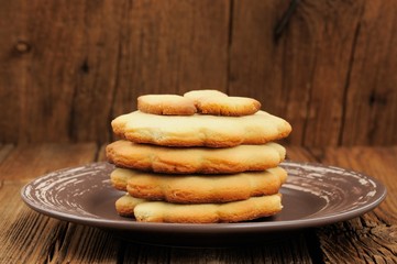 Four round sand cakes in pile decorated with small cakes on rust