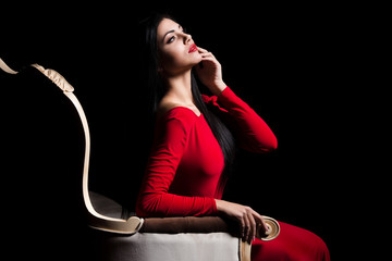 Elegant woman in red dress in darkness. Female in dramatic