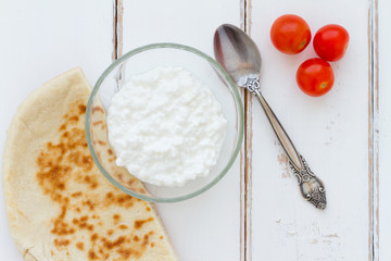Cottage cheese in a bowl on a vintage wood background