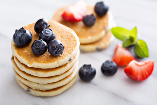 Stack of small pancakes with berries