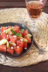 wassermelone, salatgurke und feta salat mit minze und ein glas rosé