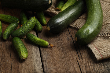 Zucchini and cucumbers on wooden background.