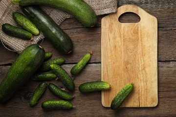 Zucchini and cucumbers on wooden background. Top view.