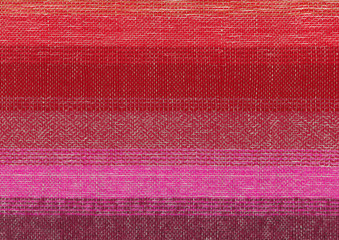 Handwoven geometric pattern in red, pink and purple