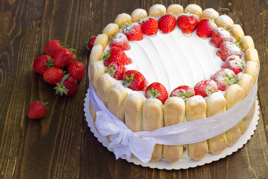 Strawberry cake Charlotte, ladyfingers built around a creamy mousse center with layers of fresh berries. Luxury light summer cake