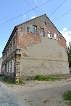 The old peeled-off building of the German construction in the ci