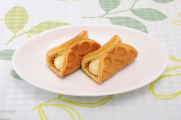 お皿にのせた ワッフル ロール カスタードクリーム テーブル