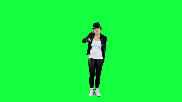 Girl in the hat dancing like the king of pop. Chroma key background. Young woman dancing against a green background
