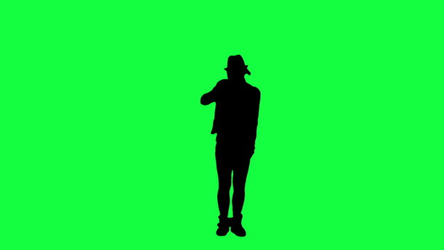 Silhouette of a girl in the hat dancing like the king of pop. Chroma key background. Silhouette of a woman dancing against a green background
