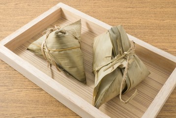 Two Zongzi or Sticky Rice Dumpling on Wooden Tray