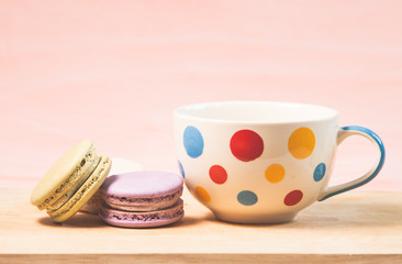 Obraz na płótnie Canvas French macarons and cup on table