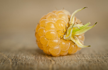 Ripe sweet yellow raspberry on the wooden table