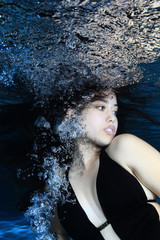 Fototapeta premium Young woman underwater with air bubbles 