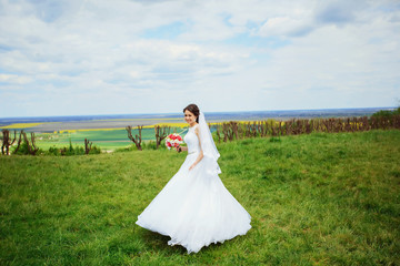 Portrait of a beautiful bride outdoor in the park, smiling bride