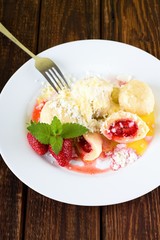White plate with fruit damplings and whole berries