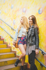 two beautiful blonde and brunette girl having fun in the city