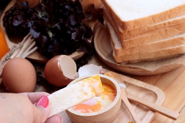 soft-boiled egg with bread on wood background.