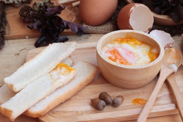 soft-boiled egg with bread on wood background.