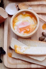 soft-boiled egg with bread on wood background.