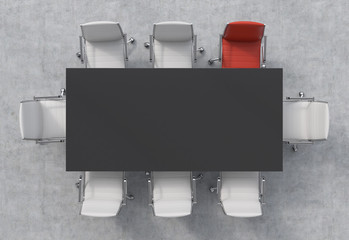 Top View of a conference room. A black rectangular table and eight chairs around, one of them is...
