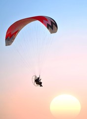 Parapendio a motore al tramonto