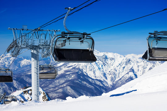 Chairs on chairlift ropeway in winter mountains