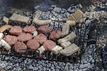 Steaks cooking over hot coals from open fire
