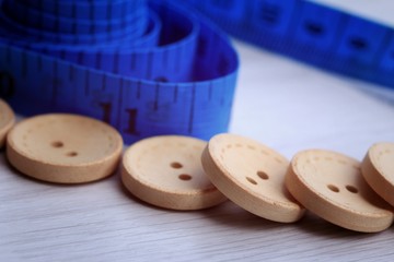 Measure tape and bobbin and wood buttons.