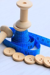 Measure tape and bobbin and wood buttons.