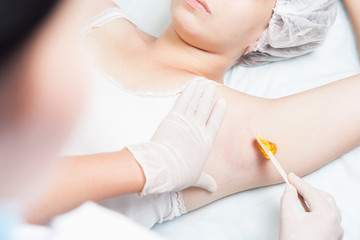 Fototapeta na wymiar Professional woman at spa doing epilation armpits using sugar - sugaring