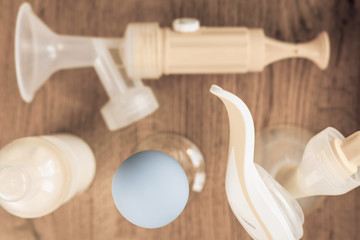 Fototapeta na wymiar Background of manual and automatic breast pump, baby bottle with milk. Mothers breast milk is most healthy food for newborn baby. Selective focus
