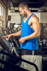 Fototapeta na wymiar Man setting treadmill