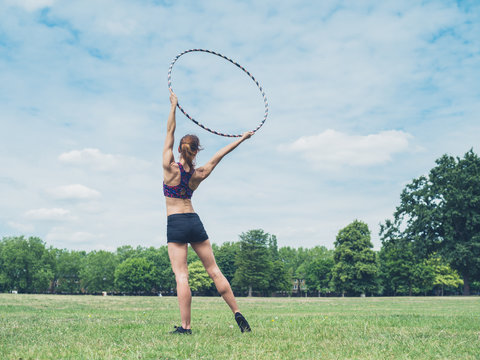 Woman standing in park with hula hoop