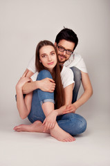 Young couple sitting close on the floor and holding hands