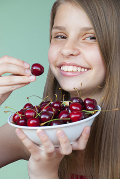 Portrait of beautiful teenage girl with cherries