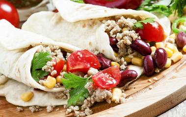 Traditional Mexican burritos with meat and beans, selective focu