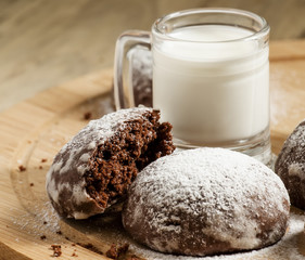 Homemade chocolate cookies sprinkled with powdered sugar and mil