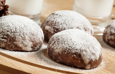Homemade chocolate cookies sprinkled with powdered sugar and mil