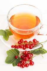tea in cup and fresh red currant