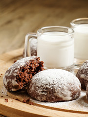 Homemade chocolate cookies sprinkled with powdered sugar and mil