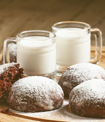 Homemade chocolate cookies sprinkled with powdered sugar and mil